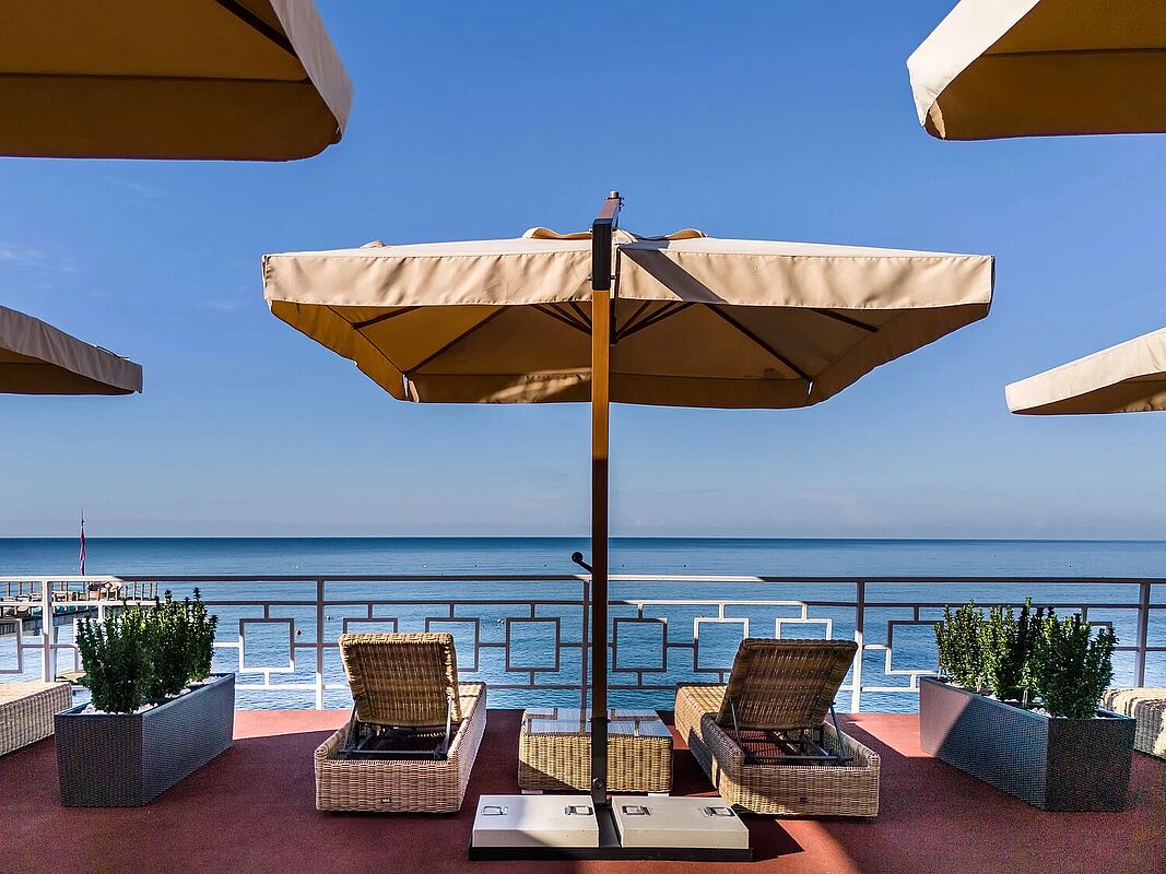 Уютная терраса с шезлонгами и зонтиками