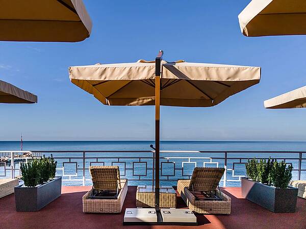 Уютная терраса с шезлонгами и зонтиками